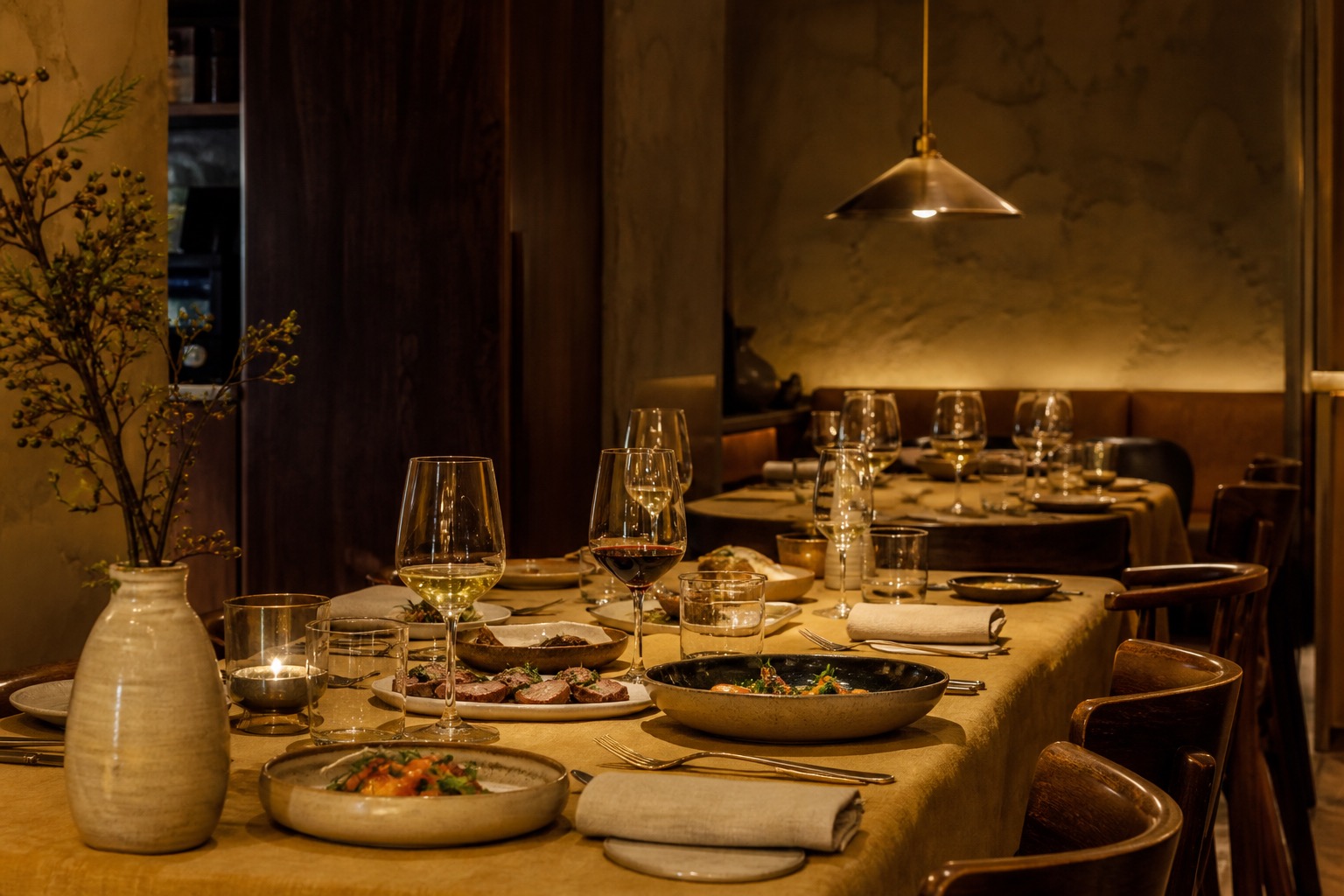 Stół w restauracji nakryty ceramiką i sezonowymi daniami